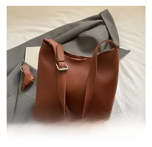 Detail of dark brown lychee grain leather tote with adjustable silver buckle strap