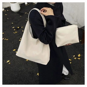 Close-up of cream Hobo shoulder bag and matching clutch in soft synthetic leather
