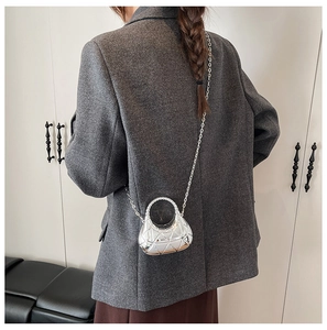 Gros plan du mini sac croissant argenté avec texture géométrique et bandoulière chaîne