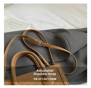 Detail of adjustable leather strap with silver metal buckle on brown tote bag