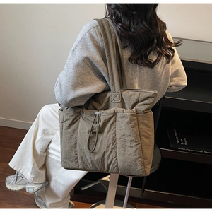 Detail of the olive green padded tote bag with unique drawstring texture on shoulder