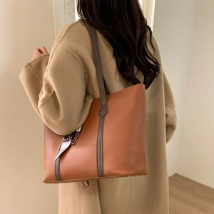 Caramel brown leather tote bag with silk scarf detail worn with a camel coat