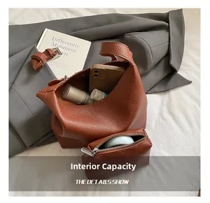 Detail of brown lychee texture leather bucket bag set with inner pouch and storage space