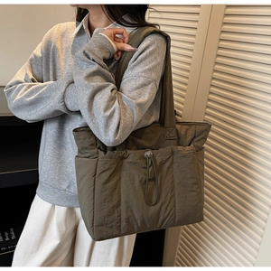 Detail of vintage olive green padded tote bag with drawstring and wide shoulder strap