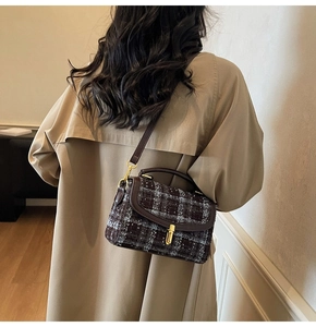 Detail view of retro brown plaid tweed handbag with leather trim and gold metal lock clasp