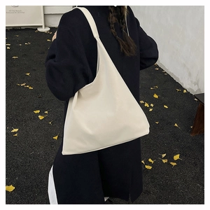 Minimalist beige hobo shoulder bag shown on model for a trendy retro commuter look