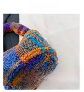 Detail view of colorful checkerboard plush bag showing fine stitching and wool-like texture