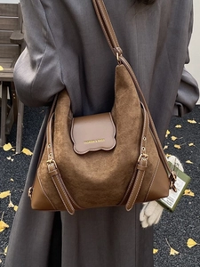 Sac bandoulière vintage en daim marron présenté dans une scène de rue d'automne