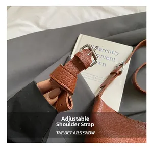 Detail of adjustable brown pebble leather strap with a silver metal buckle closure