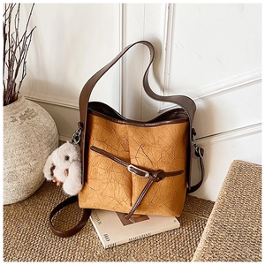 Detail of vintage pleated leather hobo bag with a plush rabbit charm and silver buckle