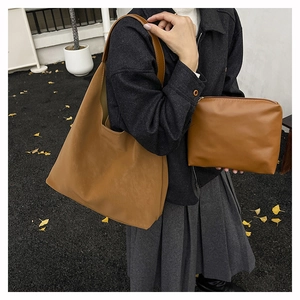 Close-up of brown leather tote bag and matching pouch showing smooth matte texture