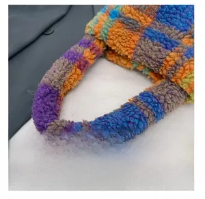 Close-up of rainbow checkerboard plush tote bag showing soft wooly fabric texture