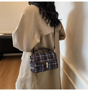 Close-up of vintage plaid tweed flap bag with gold twist lock and brown leather handle