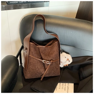 Brown pleated bucket bag detail with dark brown leather strap and rabbit plush pendant