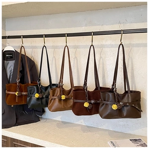 Detail view of large capacity tote bags in multi-colors with metallic buckle and fur pompom