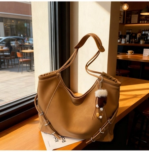 Sac cabas marron avec boucles argentées latérales et breloque pompon en fourrure