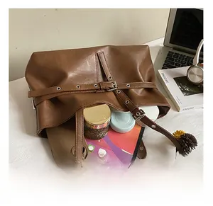 Macro shot showing large capacity of the brown tote bag with phone and tablet inside