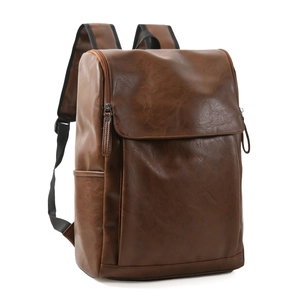 Detail view of brown leather backpack with front flap, side pockets and adjustable straps
