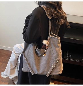 Détail du sac cabas gris avec boucle réglable et breloque en peluche et perles en bois