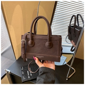 Detail view of a vintage dark coffee handbag with silver text and a matching shoulder strap