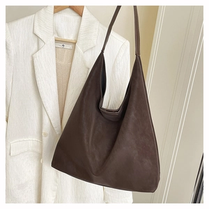 Detail of minimalist dark coffee tote bag with vintage matte leather finish and shoulder strap