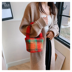 Detail of checkered teddy fleece bucket bag held by model in warm indoor setting