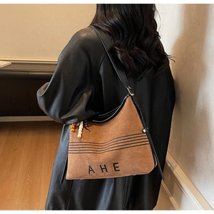 Detail of vintage brown suede tote bag with AHE embroidery and colorful beaded tassel