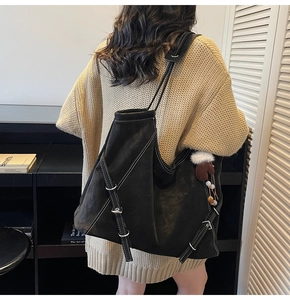 Détail d'un grand sac cabas noir avec coutures blanches contrastées et boucles argentées