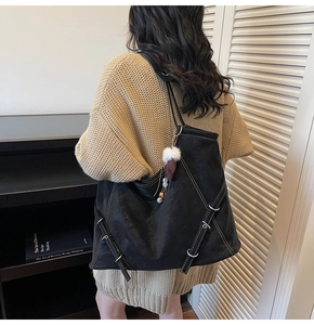 Détail du sac cabas noir montrant les coutures contrastées et les boucles latérales
