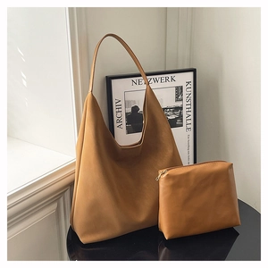 Deep camel leather hobo bag set with matching zipper pouch on a minimalist table