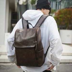 Detail of dark brown vintage leather backpack with side zipper and flap closure