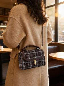 Vintage brown plaid shoulder bag with gold twist lock shown in a warm cafe setting