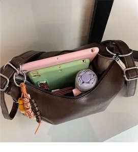 Macro view of large capacity tote bag interior with tablets and colorful bead charm