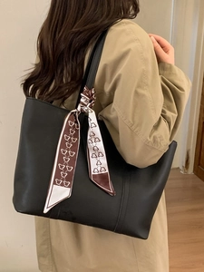 Minimalist black leather tote bag with stylish silk scarf detail for elegant daily commute