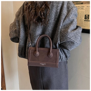 Detail of vintage dark brown PU leather handbag with unique spherical handle connectors