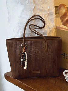 Dark brown woven leather tote bag with stylish beaded tassel and long shoulder straps