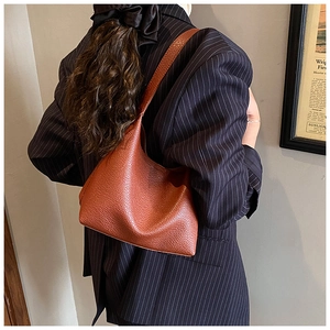Braune Hobo-Tasche aus Leder mit Lychee-Maserung zu einem minimalistischen Business-Outfit
