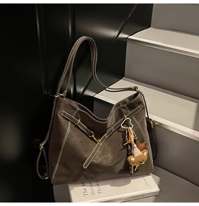 Detailed view of the dark brown hobo bag featuring contrasting white stitching and gold hardware