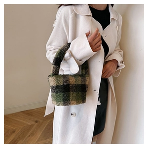 Detail of plush checkered mini bucket bag with soft lamb wool texture in retro green tones