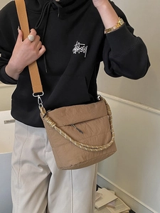 Quilted khaki nylon crossbody bucket bag with wide woven strap and decorative rope handle