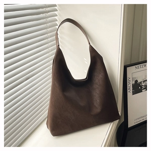 Detail view of large dark brown hobo shoulder bag with matte texture and wide strap