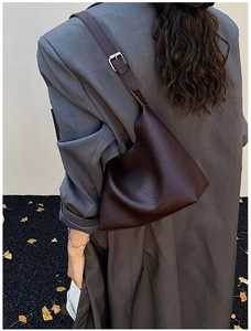Modell mit dunkelbrauner Schultertasche aus Leder mit Silberschnalle im Herbst-Ambiente