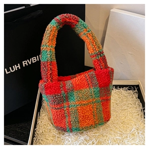 Detailed view of colorful plaid faux shearling tote bag in a premium gift box setup