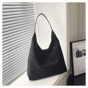 Detail view of black hobo bag with matte finish and wide strap for daily commute