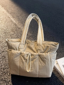 Quilted padded tote bag in beige with front drawstring pocket and large top handles