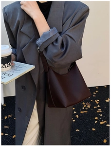 Detail of dark brown pebble leather shoulder bag with adjustable strap and chic structure