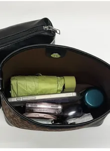 Spacious interior of leopard print bucket bag holding phone, umbrella and makeup items