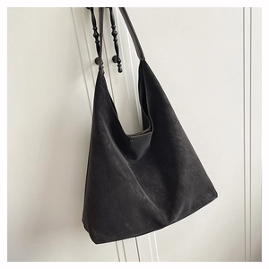 Close-up of matte charcoal hobo tote bag with detailed stitching and durable strap