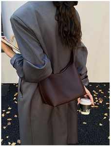 Dunkelbraune Hobo-Tasche aus strukturiertem Leder am Model in herbstlicher Pendler-Szenerie