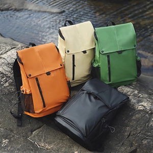 Sacs à dos extérieurs imperméables en quatre couleurs sur des rochers au bord d'un ruisseau